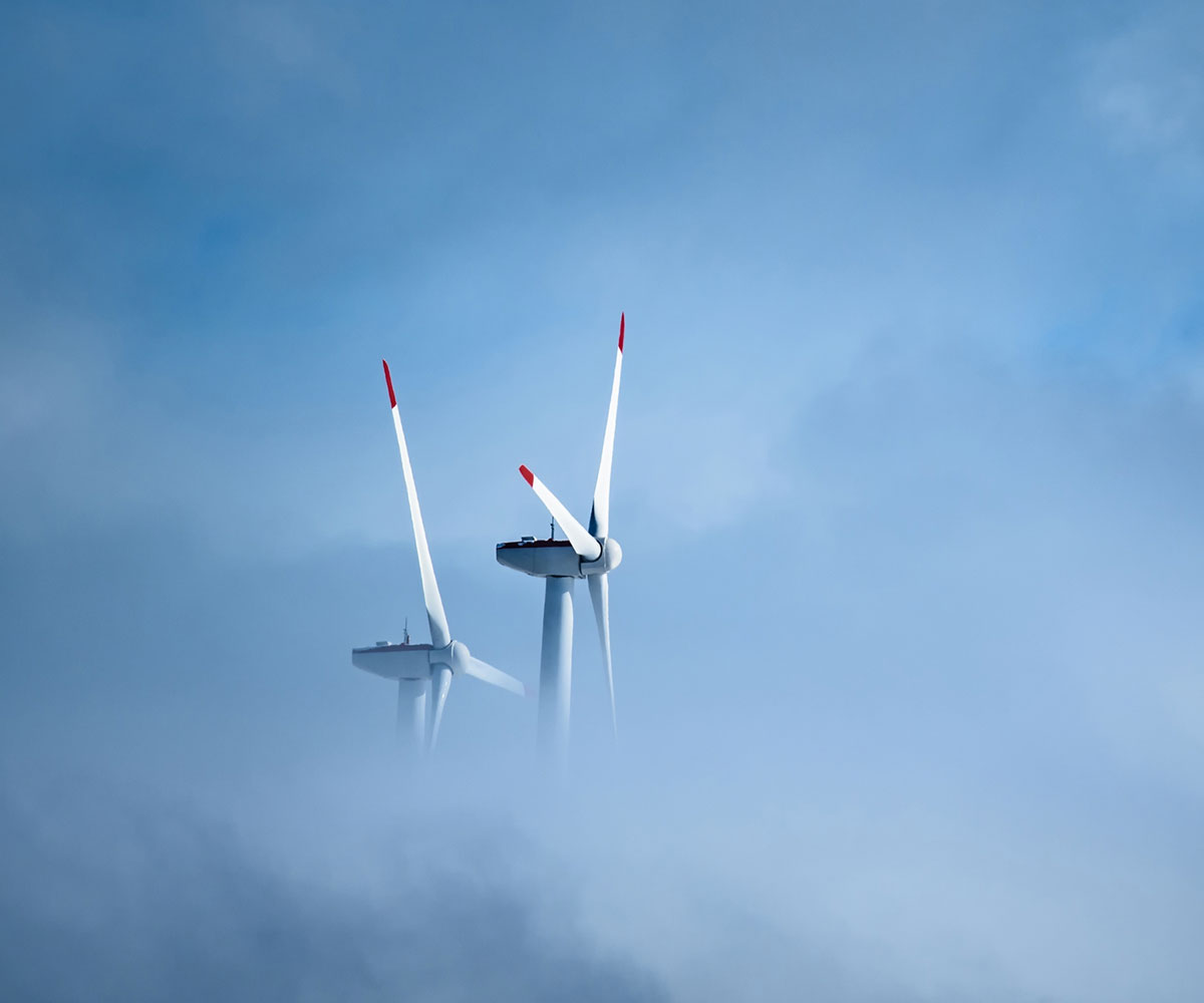 Wind turbines appearing over clouds